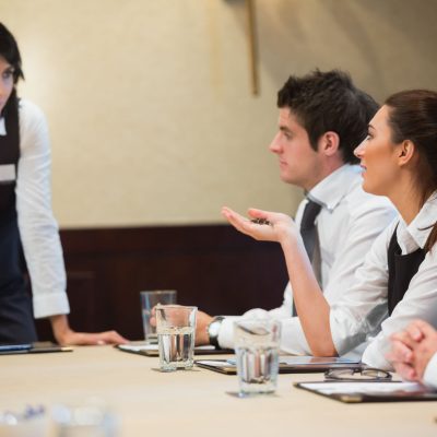 Woman asking question in business meeting in conference room